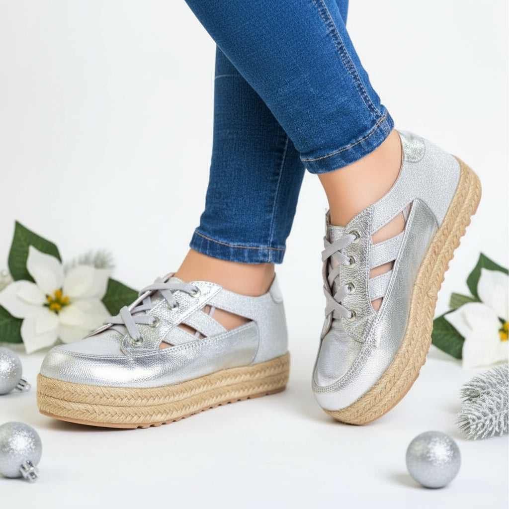 A pair of silver metallic women's sneakers with a jute platform sole,
