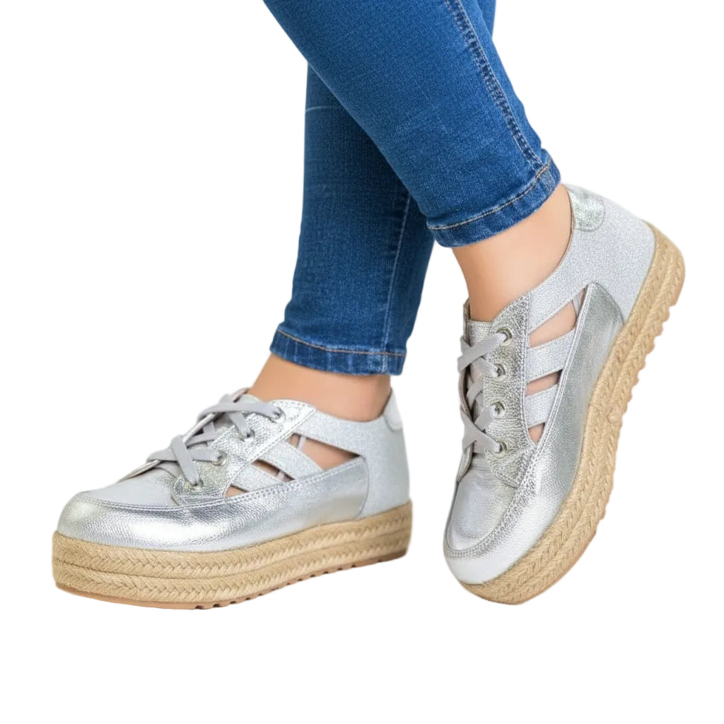 A pair of silver metallic women's sneakers with a jute platform sole,