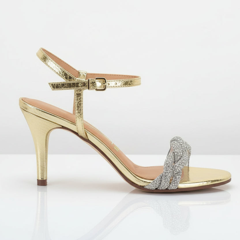 A gold-colored strappy sandal with a heel and rhinestone embellishments.