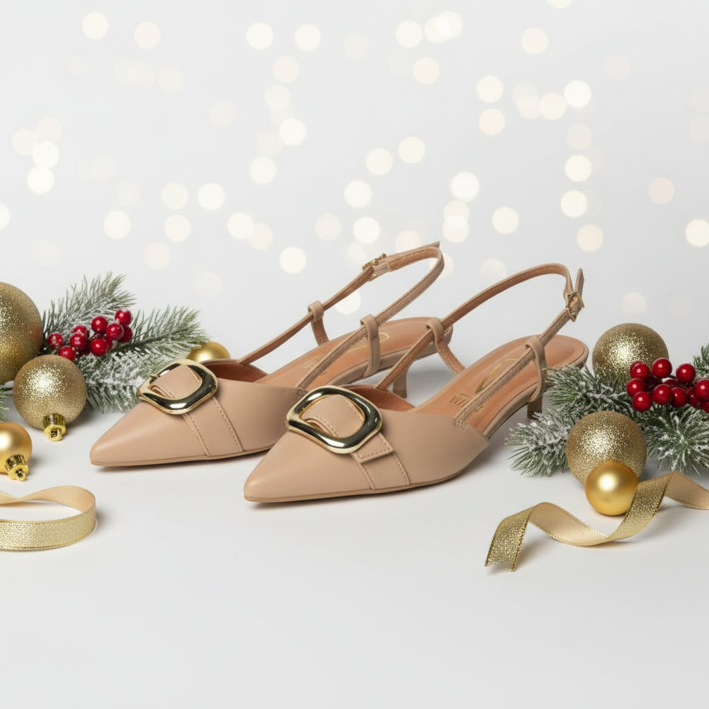 A pair of beige pointed-toe kitten heels with a thin strap and buckle detail.