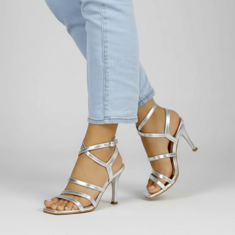 A pair of silver strappy sandals with high heels.