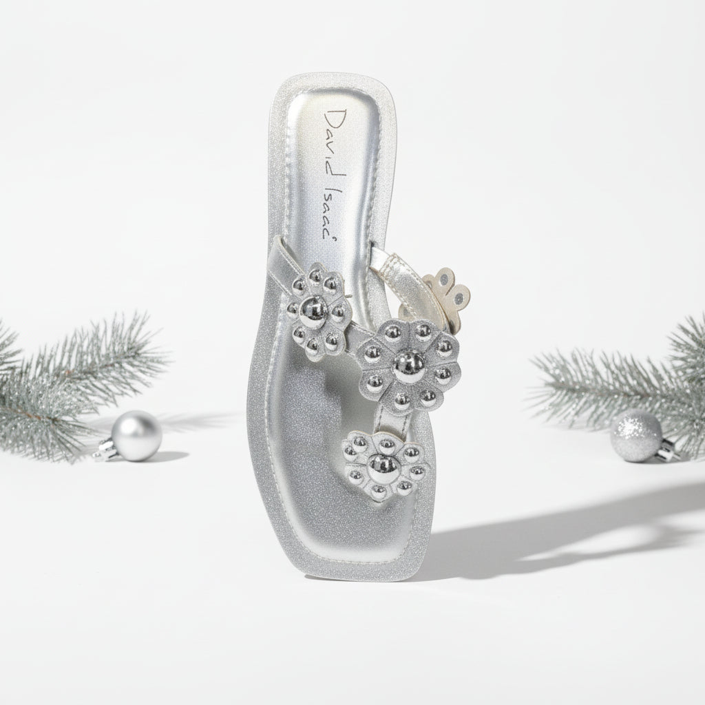 A silver flat sandal with intricate details on the upper part.