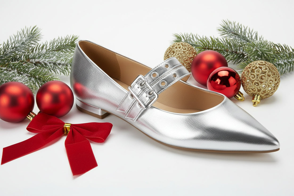 A silver pointed-toe flat shoe with a buckle strap.