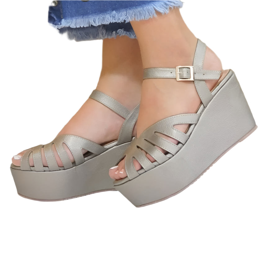 A pair of pewter-colored platform sandals with buckle strap and multiple perforations on the upper part.