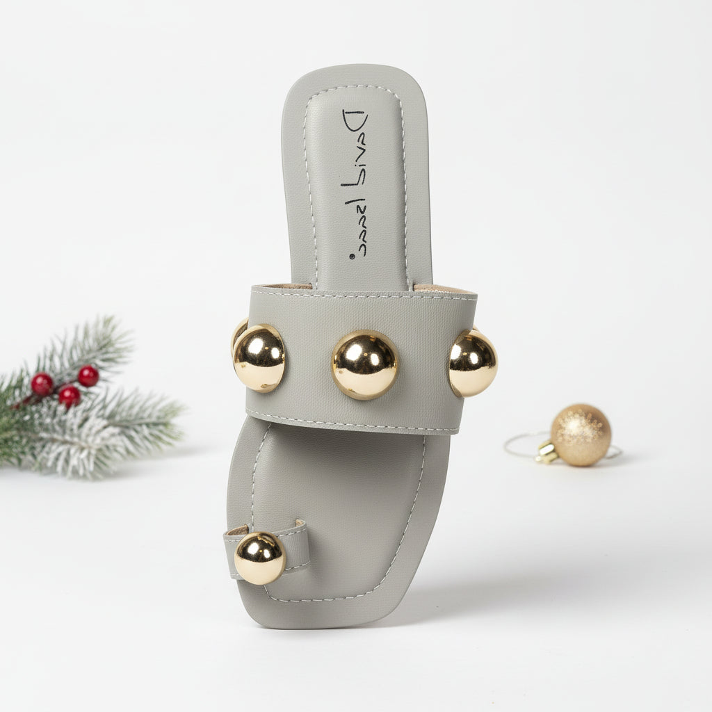 A pair of flat sandals with metallic gold details on the straps.