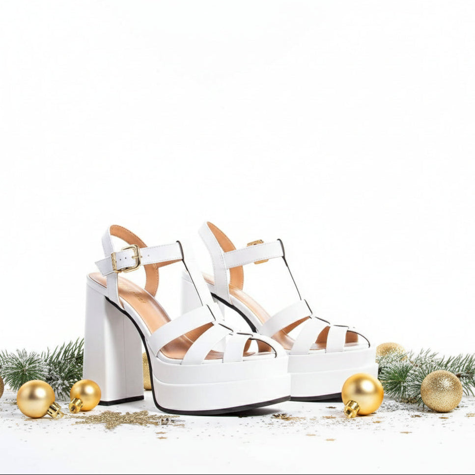 A pair of white platform heels with buckle straps and chunky heels.