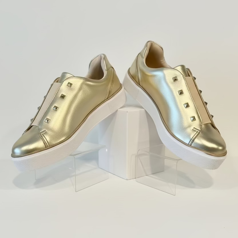 Gold sneakers with white soles.