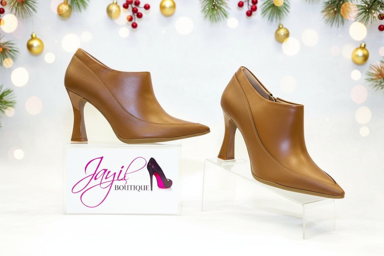 A pair of brown, pointed-toe, high-heeled boots.