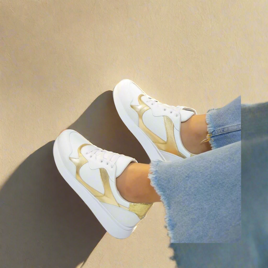 A pair of white sneakers with gold accents.